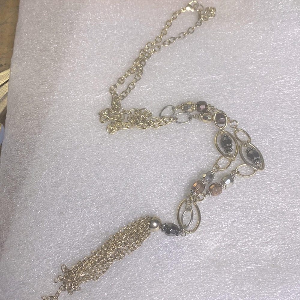 Large hanging gold tone necklace with reflective beads and gold tassels